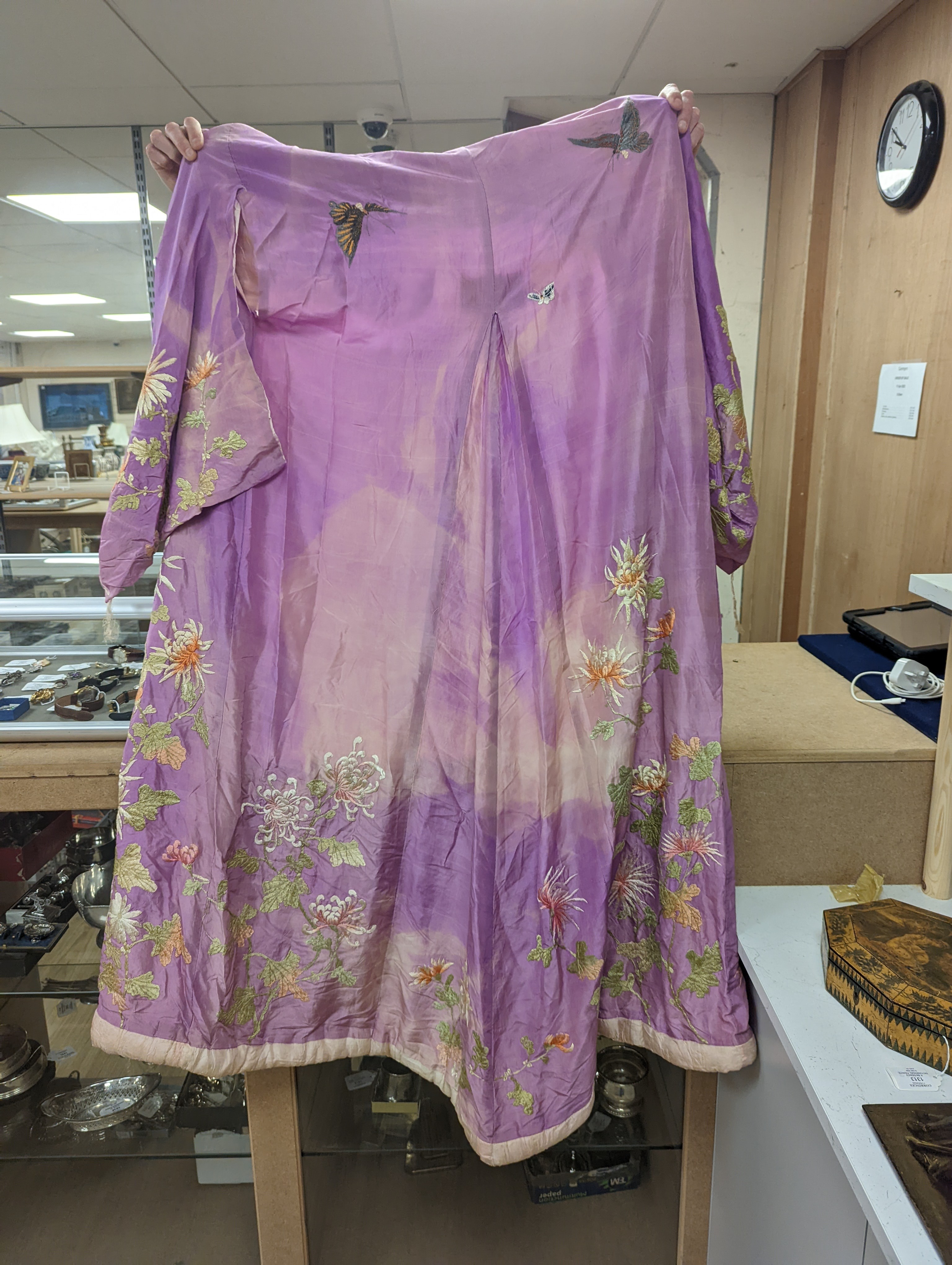 A Japanese silk kimono embroidered on mauve silk with multi-coloured butterflies and flowers, together with a cream silk unmade up kimono richly embroidered with a dragon design